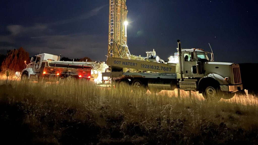 Two Commercial Well Drilling Semi Trucks at Job Site at Night